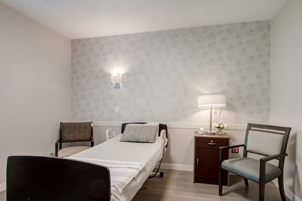 Bright and cozy resident room with bed and chairs