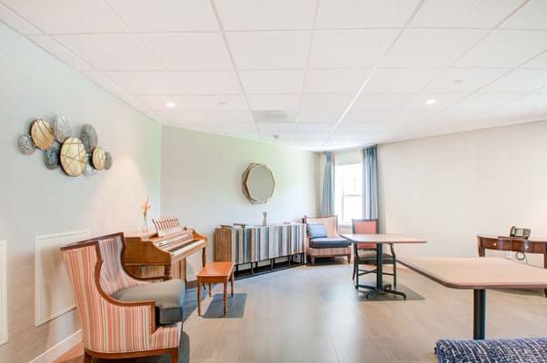 Bright common area with seating and a piano