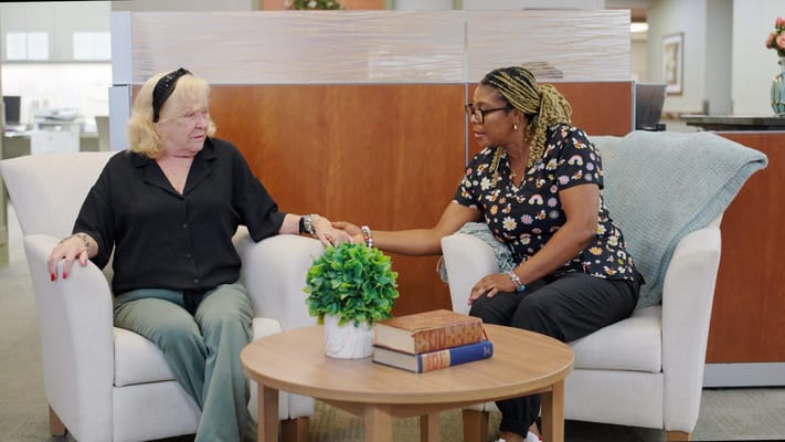 Two residents engaging in conversation in a common area