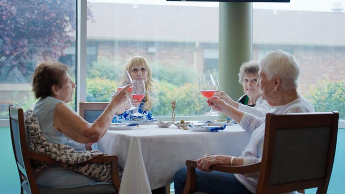 Residents toasting with drinks in a common area