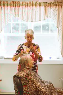 Residents receiving haircuts in a cozy salon area