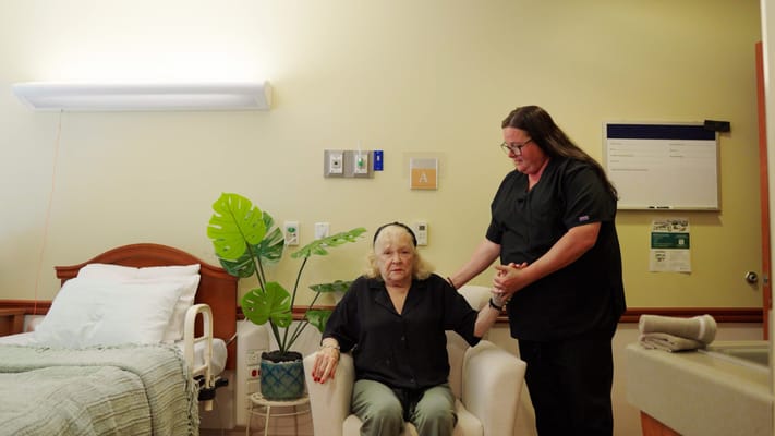 Caregiver assisting a resident in a room
