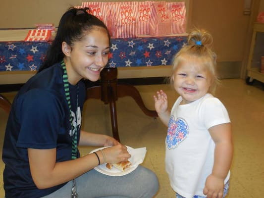 A staff member and a child enjoying popcorn together