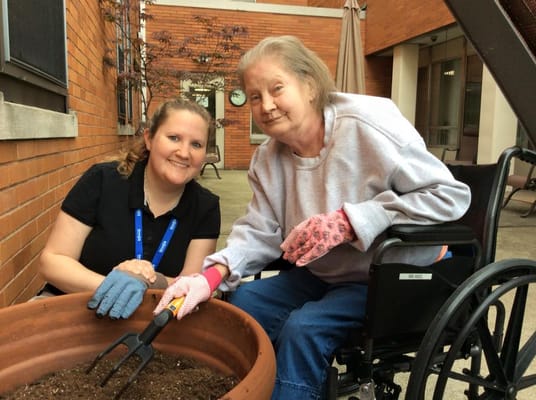Resident and staff member gardening outdoors