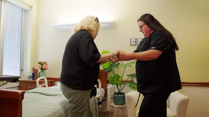 Staff assisting a resident in a cozy room