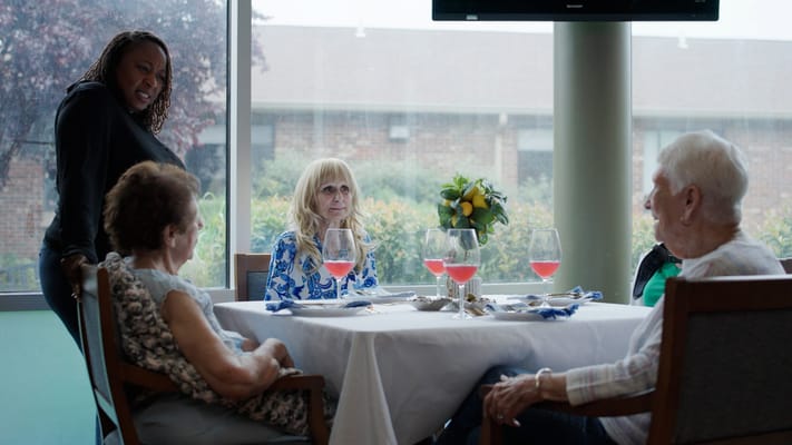 Residents enjoying refreshments at a dining room table