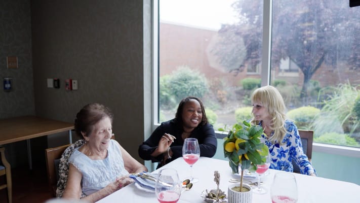 Residents enjoying a meal and conversation in the dining area
