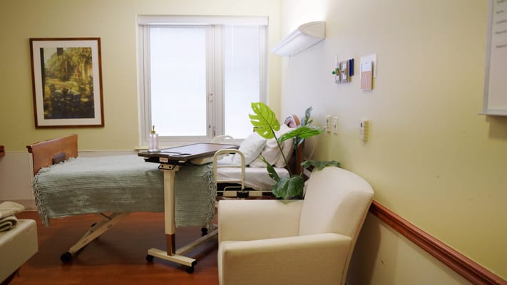 An interior view of a resident's room with a bed and chair