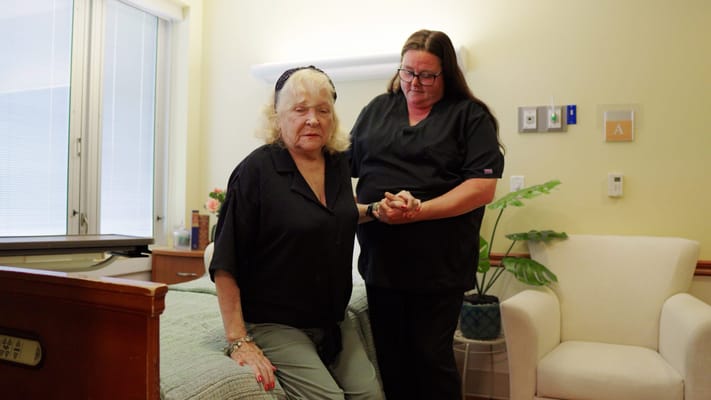 Caregiver assisting a senior resident in a room