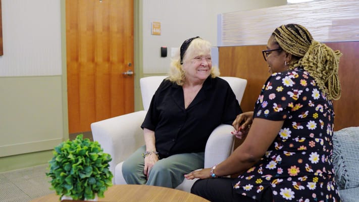 Two women chatting in a cozy common area