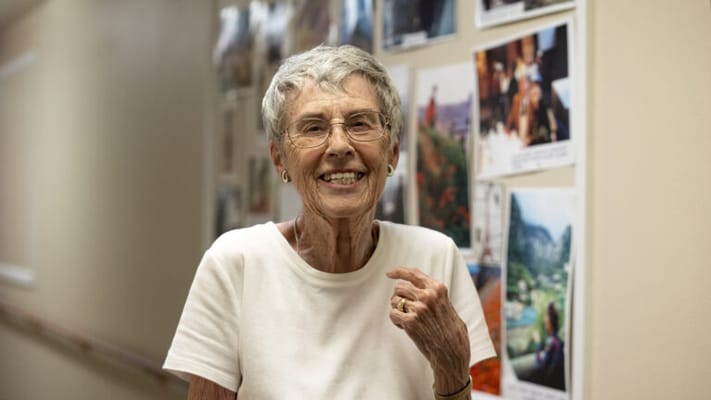 A resident smiling in a hallway with photos