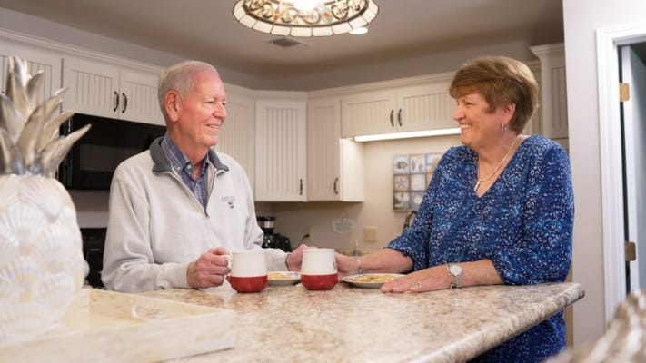 A smiling senior couple chatting in a kitchen