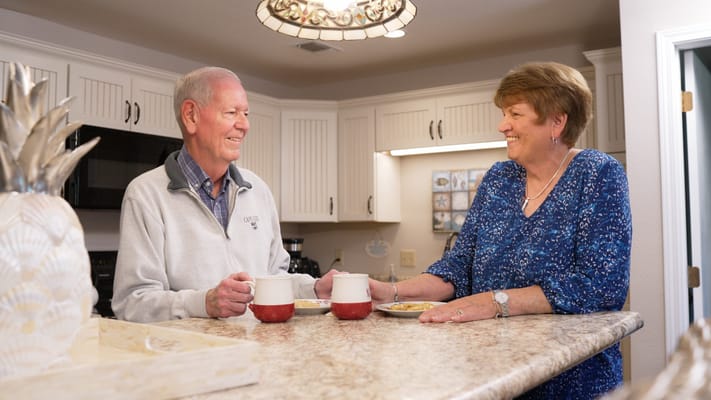 A smiling senior couple chatting in a kitchen