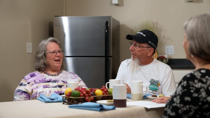 Two residents sharing a joyful moment in a dining area