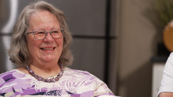 A smiling senior resident in a cozy interior setting