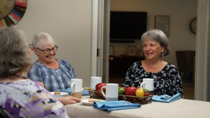 Residents enjoying conversation over snacks in a cozy setting