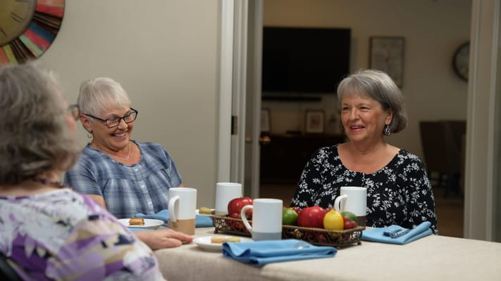 Residents enjoying conversation over snacks in a cozy setting