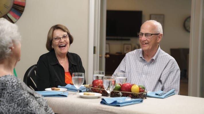 Seniors enjoying a meal and conversation in a dining area