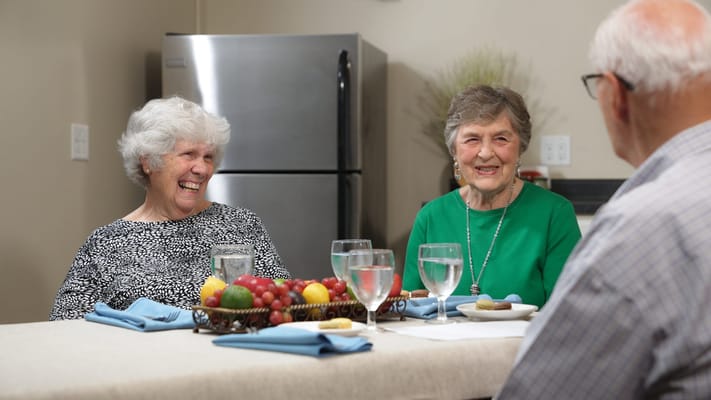 Two smiling residents enjoying a meal together