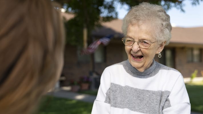 Smiling resident enjoying conversation outdoors