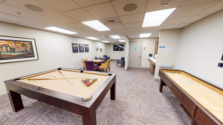 Activity room with a pool table and lounge seating