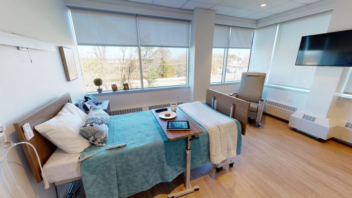 Cozy resident room with bedside table and meal tray