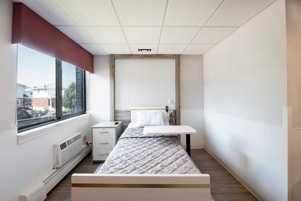 A well-furnished private resident room with bed and window