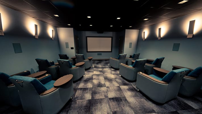 Cozy movie room with reclining chairs and screen