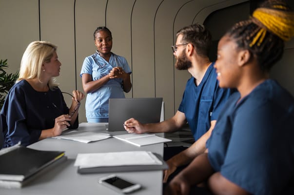 Staff members engaged in a discussion around a table
