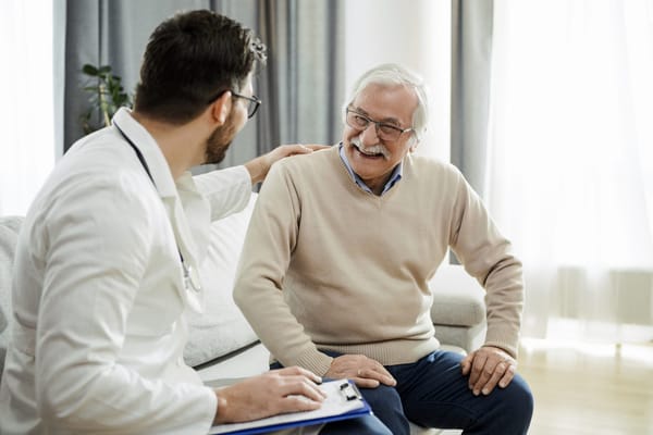 Doctor interacting with a senior resident in a cozy room