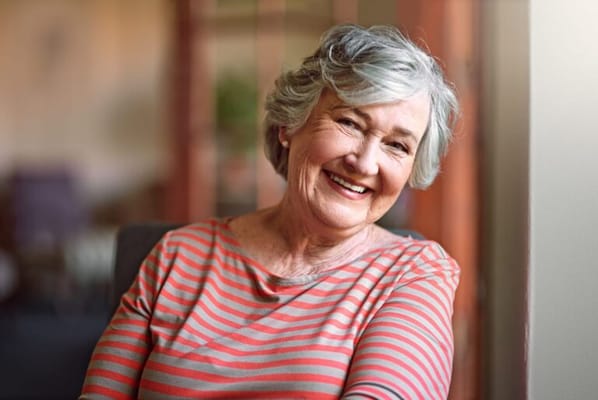 A smiling senior woman in a cozy indoor setting