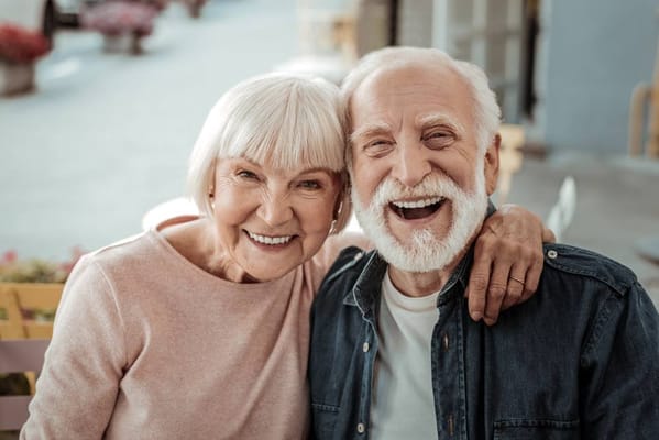 A happy elderly couple smiling at the camera