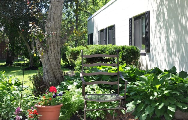 A peaceful garden area with a chair and flowers