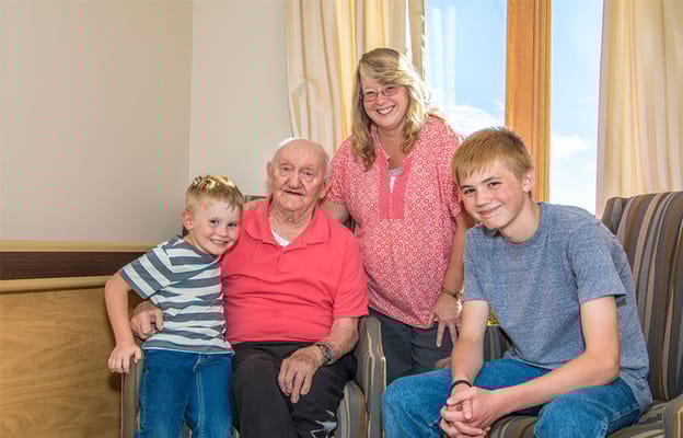 Family visiting a resident in a cozy common area