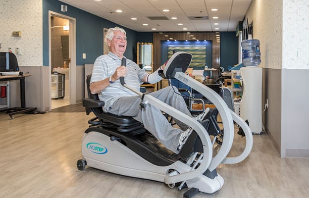 Resident exercising on a fitness machine in the common area