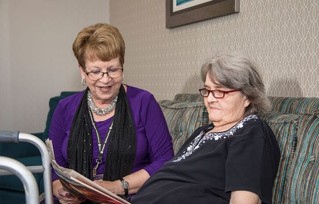 Staff assisting a resident in a cozy living area
