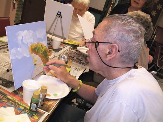 A resident painting during an art activity.