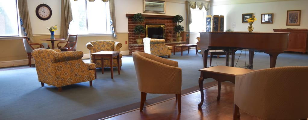 Common area with chairs and piano in a serene setting