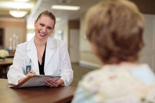 Happy staff member assisting a resident in a common area