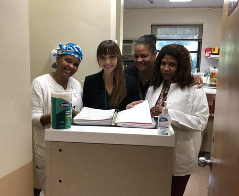 Four staff members smiling by a reception area
