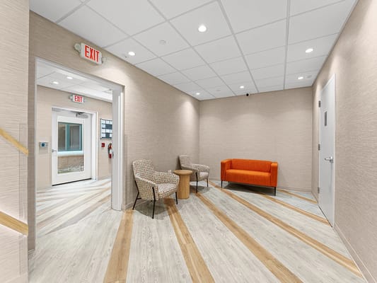 Bright lounge area with orange couch and chairs