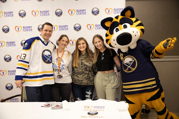 Residents and staff with a mascot at a community event