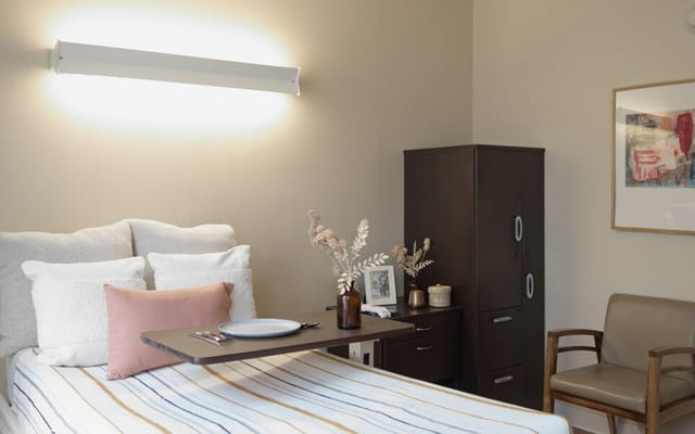 A cozy resident room with a neatly made bed