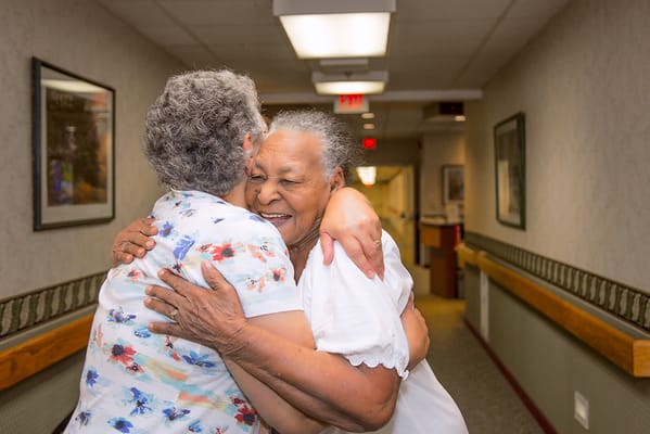 Residents hugging in a hallway