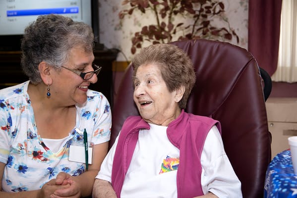 Staff member interacting with a resident in a bright activity room