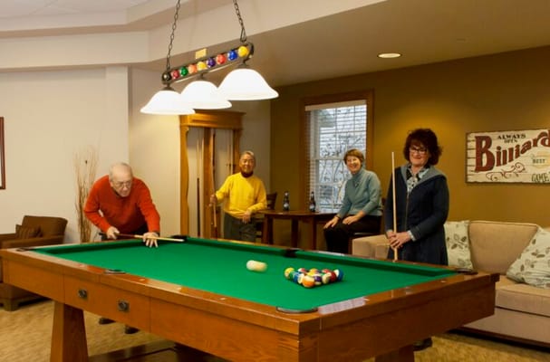 Residents playing billiards in a common area