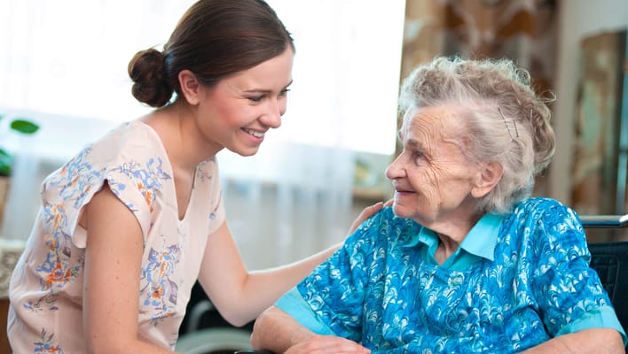 Caregiver interacting with a senior resident in a bright room