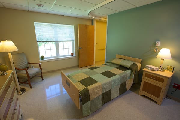 Brightly lit private resident room with a single bed