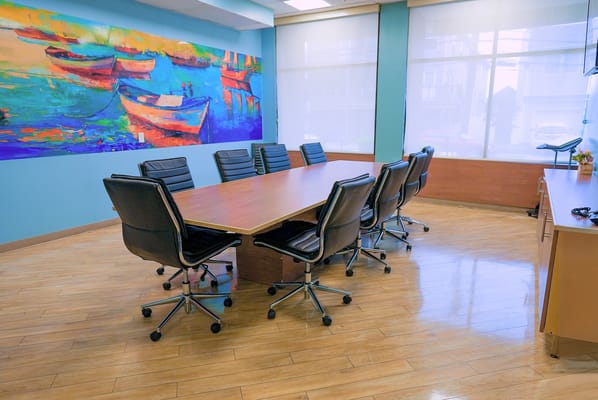 Bright conference room with a large table and colorful artwork