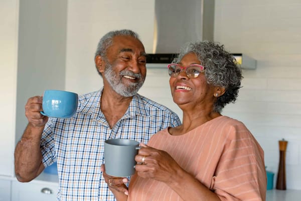 Two seniors enjoying coffee in a cozy kitchen